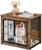 A dog is sitting inside a wooden dog crate that is designed to look like a side table. There is a vase with flowers and a cup on top of the crate. Produktbild-Vorschau