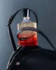 A bottle of Creed Original Santal perfume is placed on a black leather saddle. Anteprima dell’immagine prodotto