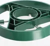 A close-up view of a green plastic Christmas tree stand. Voir les images du produit