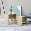Two wooden side tables are placed on a rug in a living room setting, with a blue armchair and a framed artwork in the background. Produktbild-Vorschau