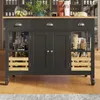 A kitchen island with storage drawers and cabinets, set against a backdrop of shelves filled with bottles and glassware. Produktbild-Vorschau