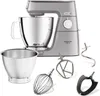 A silver Kenwood stand mixer with various attachments, displayed on a white background. Voir les images du produit
