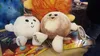 Plush toys of Pluto and Charon are displayed on a surface with other celestial-themed items. Produktbild-Vorschau