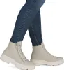 A person wearing blue jeans and beige boots. Podgląd zdjęcia produktu