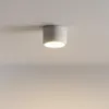 A white cylinder-shaped ceiling light fixture is mounted on a white ceiling. Náhled obrázku produktu