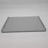 A gray metal shelf with raised edges and small clips on the sides, presented on a plain gray background. Voir les images du produit
