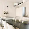 A modern dining room with a black marble table, chairs, and a contemporary chandelier. Produktbild-Vorschau