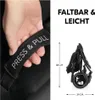 A hand is shown holding a strap with text on it, next to a folded stroller with dimensions indicated. Produktbild-Vorschau
