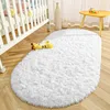 A fluffy white rug is placed on a wooden floor next to a white crib. A yellow giraffe toy is on the rug. Anteprima dell’immagine prodotto