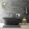 A modern bathroom with a freestanding bathtub, tiled walls, and a small stool with a plant. Náhled obrázku produktu