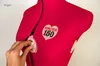 A hand is adjusting the dial on a red sewing mannequin with a Singer 150 logo. Produktbild-Vorschau