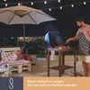A man is grilling on a patio at night, with an umbrella and string lights overhead. Podgląd zdjęcia produktu