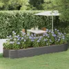 A raised garden bed filled with hydrangeas is set in a garden with a table and chairs under an umbrella in the background. Anteprima dell’immagine prodotto