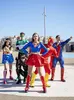 A group of people dressed as superheroes posing outdoors. Produktbild-Vorschau