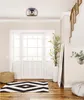 A hallway with a front door, rug, pouf, plant, and staircase. Produktbild-Vorschau