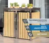A silver and wood trash bin enclosure with plants on top, set against a blurred outdoor background. Náhled obrázku produktu