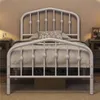 A white metal bed frame with a crown-shaped headboard is shown in a bedroom setting. Produktbild-Vorschau