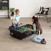 Two children are playing foosball on a foosball table in a room. Anteprima dell’immagine prodotto