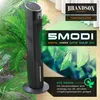 A tall, black tower fan is shown in a setting with lush green plants and natural light, suggesting a modern and eco-friendly environment. Voir les images du produit