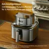 A stainless steel air fryer is placed on a wooden cutting board, with kitchen cabinets in the background. Produktbild-Vorschau