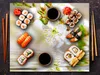 A flat lay image of sushi and cherry blossoms, with chopsticks and soy sauce. Náhľad obrázku produktu
