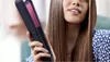 A woman is holding a hair straightener, with her hair styled straight. Voir les images du produit
