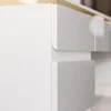 A close-up view of white drawers with gold trim on a desk. Produktbild-Vorschau