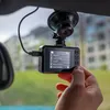 A hand is adjusting a dashcam mounted on a car windshield. Produktbild-Vorschau