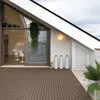 A modern balcony or patio with WPC decking, featuring a sliding glass door leading into a living space, decorative planters, and outdoor lighting. Podgląd zdjęcia produktu