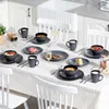 A dining table set for a meal with plates, bowls, cups, and food. Voir les images du produit