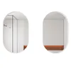 Two oval mirrors are shown against a white background. The mirror on the left reflects a bathroom interior with a shower and a ribbed wall. The mirror on the right reflects a plain wall with an orange shelf. Podgląd zdjęcia produktu
