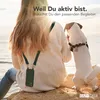 A person and a dog sitting on rocks by the sea, with a phone attached to the person's neck. Produktbild-Vorschau