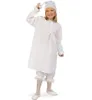 A young girl wearing a white nightgown and cap, posing for a photo. Produktbild-Vorschau