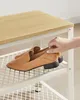 A hand is reaching for a pair of tan loafers on a shoe rack. Produktbild-Vorschau