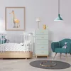 A nursery room with a crib, a dresser, and a chair. Podgląd zdjęcia produktu
