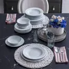 A table setting with dinnerware, cutlery, and a floral arrangement. Náhľad obrázku produktu