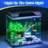 A lit-up aquarium with fish and plants, set against a dark background. Produktbild-Vorschau