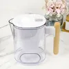A water filter pitcher on a marble countertop, with a vase of flowers in the background. Produktbild-Vorschau