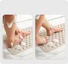 Two images showing a person's feet on a beige bath mat with soap suds. Produktbild-Vorschau