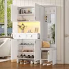 A white entryway storage unit with a shoe cabinet, bench, mirror, and hooks, set in a well-lit room. Produktbild-Vorschau
