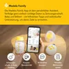 A hand holding a Medela breast milk bottle and a smartphone displaying the Medela Family app, with other Medela accessories in the background. Voir les images du produit