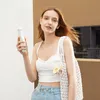 A young woman is holding a white handheld fan. Produktbild-Vorschau