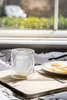 A glass with a Stormtrooper design sits on a wooden board next to a plate of fried eggs and toast, with a window and greenery in the background. Anteprima dell’immagine prodotto