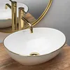 A close-up shot of a modern bathroom sink with gold fixtures. Podgląd zdjęcia produktu