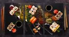 A collage of sushi and spices arranged on black platters. Náhľad obrázku produktu