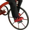 Close-up of a doll's feet on a tricycle pedal. Produktbild-Vorschau