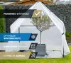 A white winter tent for plants is set up in a garden, protecting a potted olive tree. The tent has informational overlays. Produktbild-Vorschau