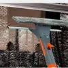 Grauer und oranger Fensterreiniger mit Mikrofaserpad und Abzieher, reinigt ein Fenster mit Wassertropfen Voir les images du produit