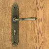 A close-up of a door handle on a wooden door. Produktbild-Vorschau