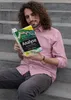 A man is sitting on stairs reading a book about financial markets. Náhľad obrázku produktu